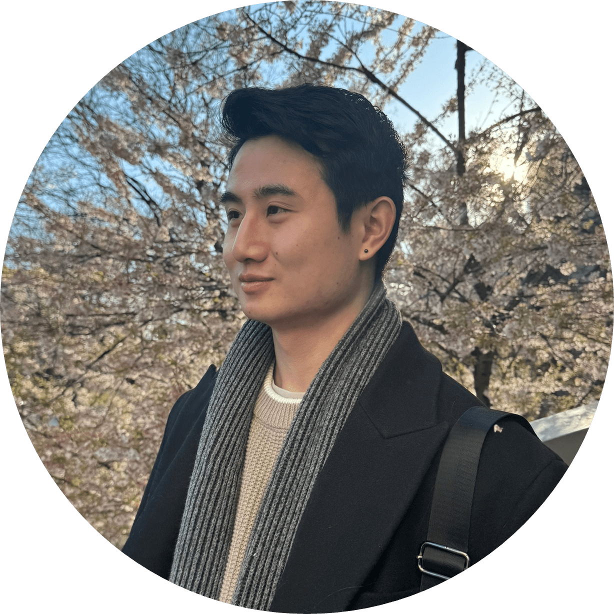 Kevin Bai standing beneath flowering trees